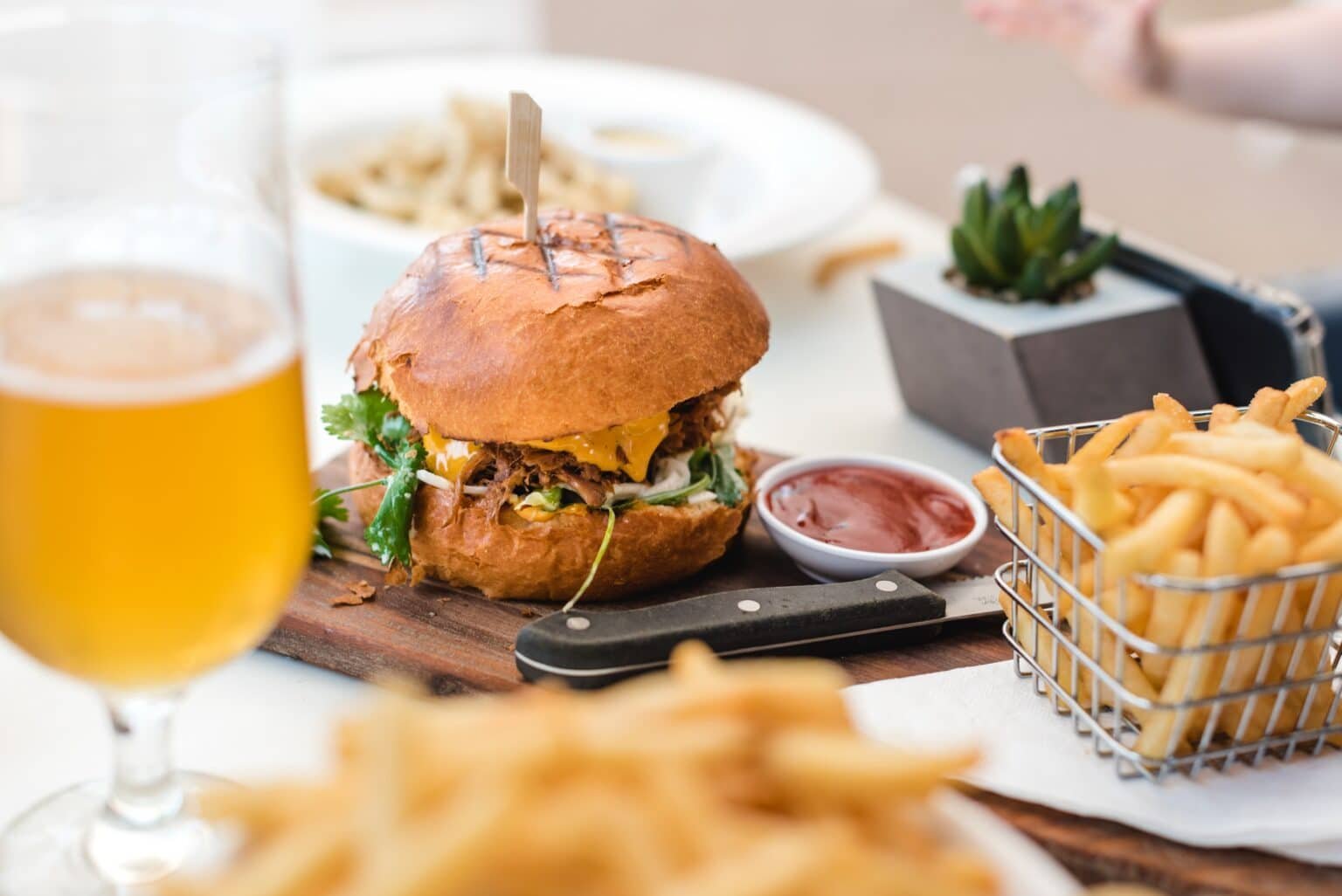 burger with chips on table with beer